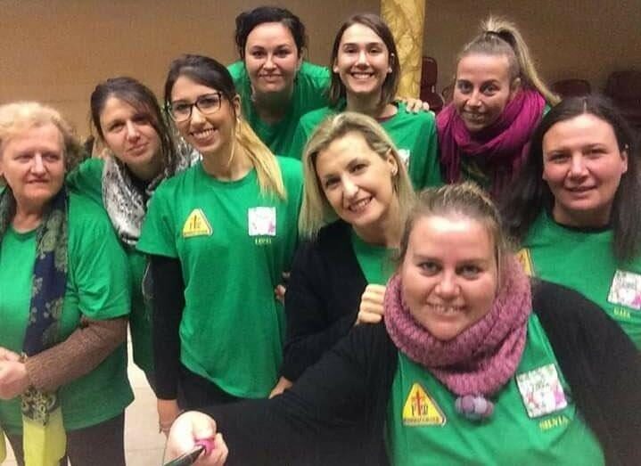Un gruppo di volontarie con le magliette verdi, sorridenti, in un selfie.